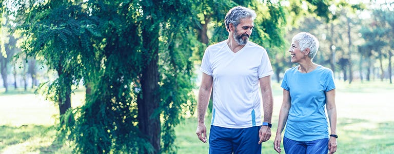 Active mature couple having a walk in the park.